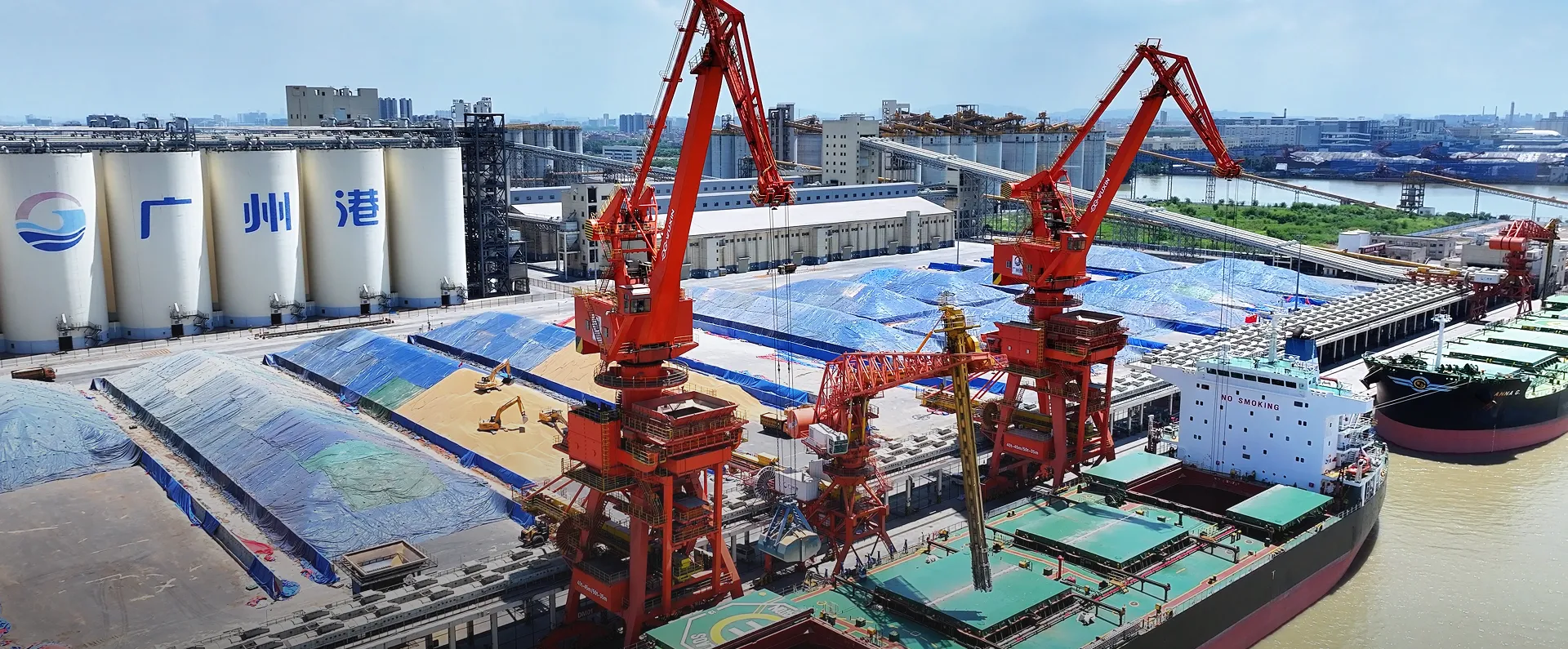 Port terminal with red portal cranes beside the sea for steel mills
